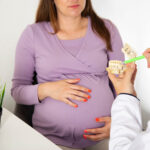 Photo of pregnant woman discussing wisdom tooth extraction during pregnancy.