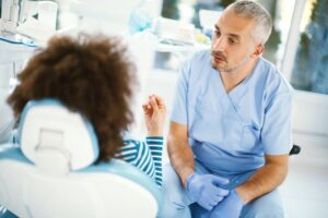 A surgeon speaking with a patient in an exam room