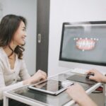 A doctor review a 3d image of her patients mouth with them