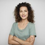 a smiling woman in a green shirt