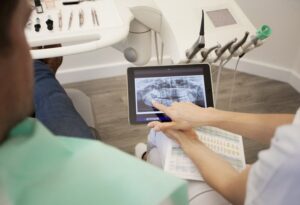 Oral surgeon reviewing implant placement case with patient