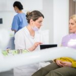 A dental assistant educating a patient during their dental visit